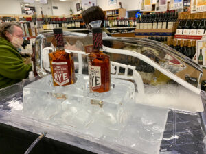 two bottles of whiskey sitting on ice in a store
