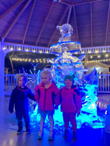 two children standing in front of a ice sculpture