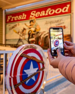 a person taking a picture of a captain america shield
