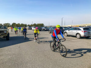 a group of bicyclists riding in a parking lot