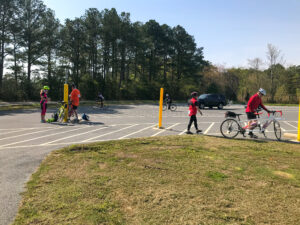 a group of people walking and riding bikes in a parking lot