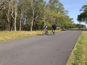 two bicyclists are riding down the road