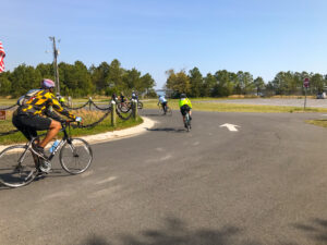 a group of bicyclists riding down the road