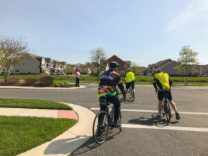 a group of bicyclists riding down the street