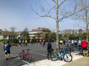 a group of people standing in a parking lot next to bicycles