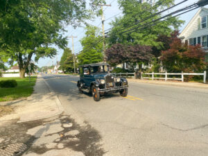 an old car is driving down the street