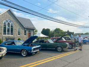 several classic cars parked in front of a church