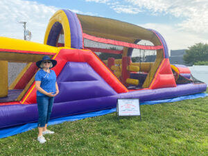 a woman standing in front of a bouncy house