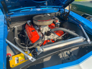 the engine compartment of a blue car with its hood open