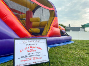 an inflatable bounce house with a sign on the grass