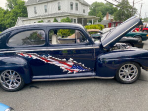 an old blue car with the american flag painted on it