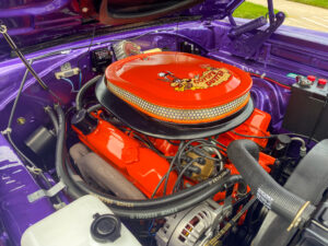 the engine compartment of a purple car with an orange top