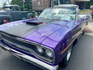 a purple muscle car parked on the side of the road