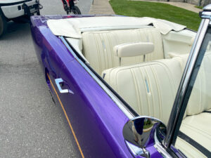 the interior of a purple convertible car parked in a parking lot