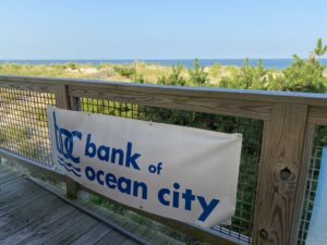 a bank of ocean city sign on a wooden deck