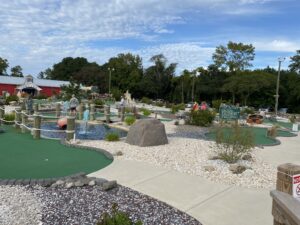 a miniature golf course with people playing in the background