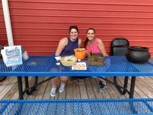 two women sitting at a blue table smiling