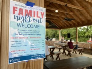 a family night out welcome sign hanging from a wooden structure
