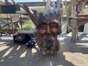 a wooden statue of a horned animal on a deck