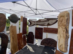 a group of wooden carvings on display under a tent