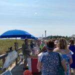 a group of people standing on a boardwalk