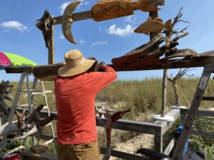 a man in a straw hat is working on a wooden structure