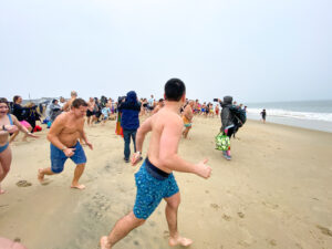a group of people running on the beach