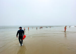 a man in a wet suit walking into the ocean