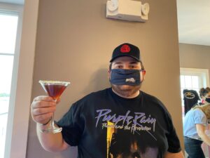 a man wearing a face mask holding a drink
