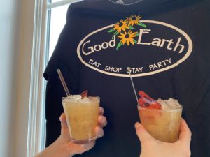 two people holding up drinks in front of a window