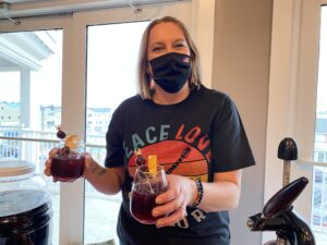 a woman wearing a face mask holding a drink