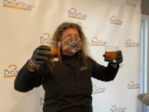 a man holding up two glasses with liquid in them