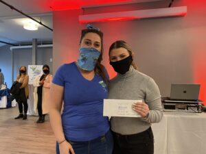 two women wearing face masks pose for a photo
