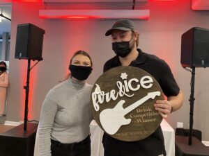 a man and woman wearing face masks holding a sign