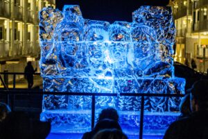 a large ice sculpture is lit up at night