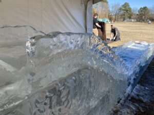 two men are working on an ice sculpture
