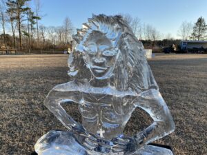 an ice sculpture of a woman sitting in the grass