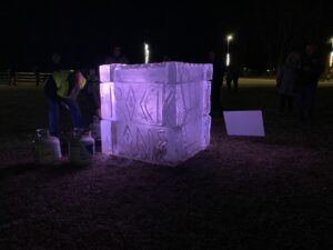 a group of people standing around an ice block