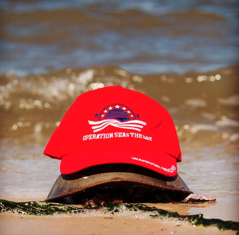 a red hat sitting on top of a sandy beach