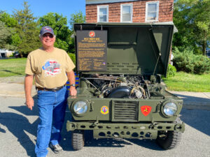 a man standing next to an army jeep