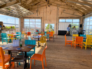 a restaurant with tables and chairs that have been painted orange, blue, yellow and green