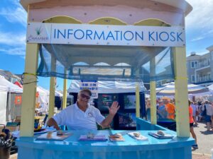 a man sitting at a blue table with information kiosk