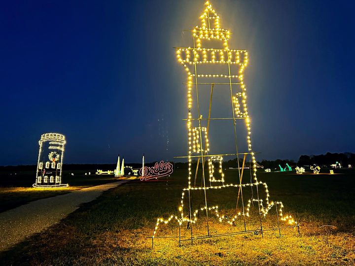 a lighted tower in the middle of a field