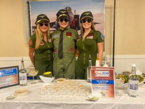 three women in green uniforms standing behind a table