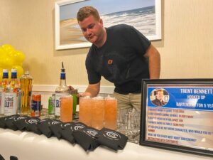 a man standing behind a bar filled with drinks