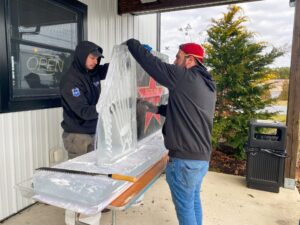 two men are working on an ice sculpture