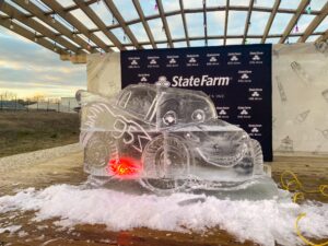 an ice sculpture of two cars in front of a state farm sign