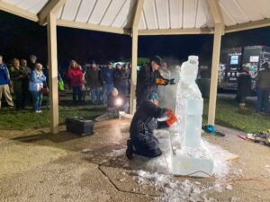 a group of people standing around an ice sculpture