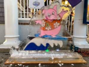 an ice sculpture of a pig on a surfboard
