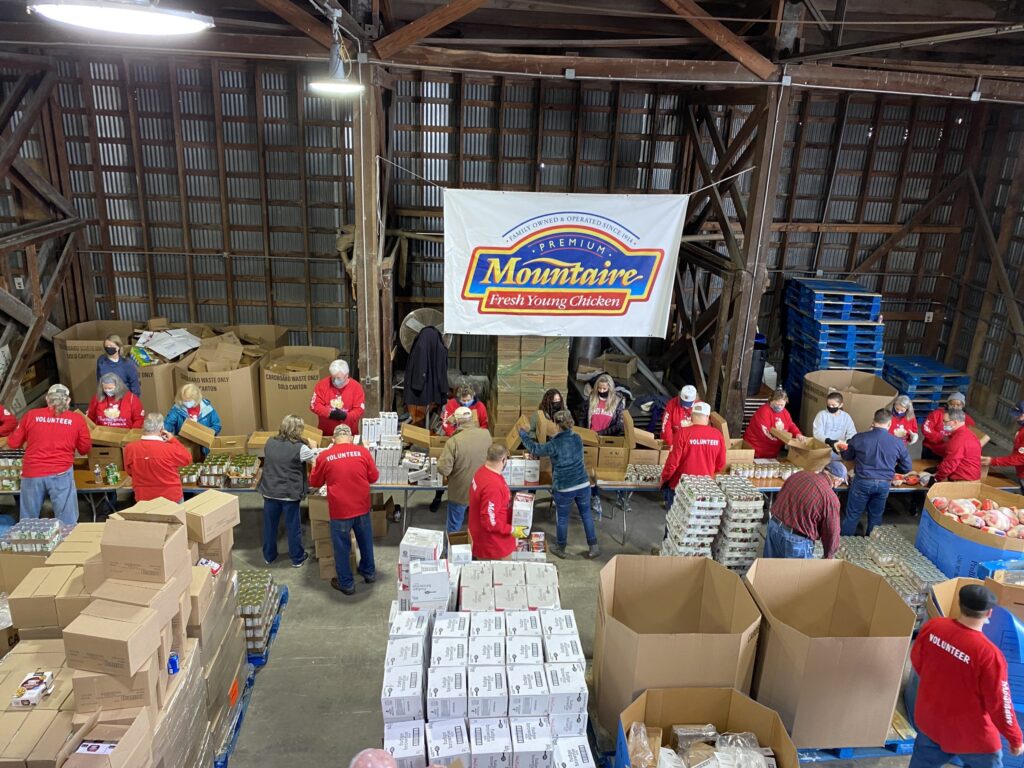 people in red shirts are standing around boxes